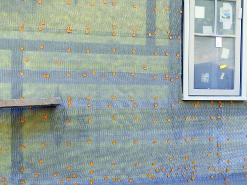 Once all the polyiso had been installed around the house, the carpentry crew installed a drainage-plane material—in this case, Benjamin Obdyke’s Home Slicker. This material is a dimensional matrix that provides a channel to drain any water that is driven through the stone face and mortar joints.