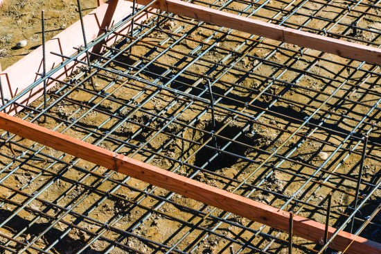 The structural mat required two grids of steel, one sitting on rebar chairs and the other hung from 2x4s laid across the forms.