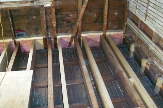 I needed to provide attachment for the subfloor along the walls running parallel to the joists, but it would have been wasteful to run a full LVL joist where I just needed a "nailer" below the studs. Instead, I screwed vertical blocks to the beam that forms the plate every 16 inches to catch the edge of the OSB subfloor.