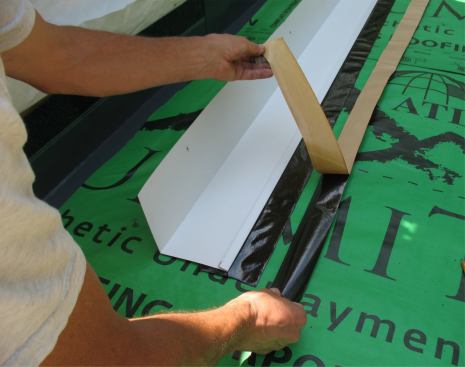 ... then peels the release backing from the strip stuck to the flashing, and the backing from half of the second strip.