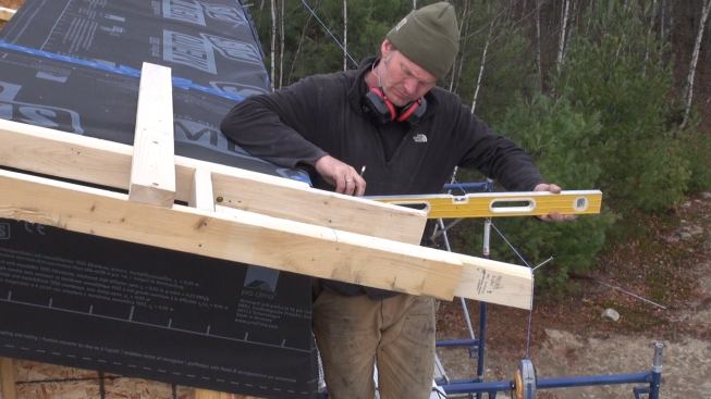 Leveling back to the wall framing face from the top edge of the rafter overhang.