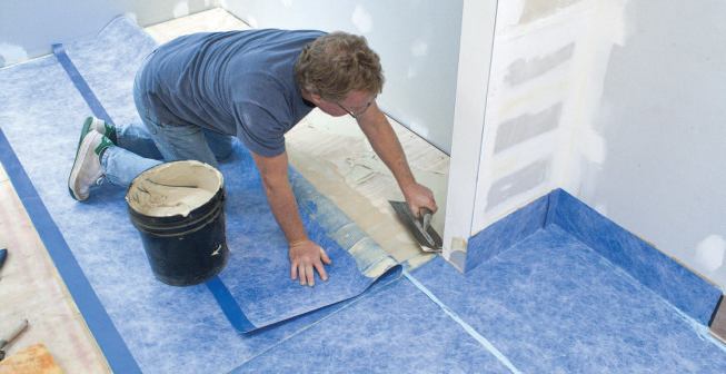 With the front of the sheet laminated, he pulls the back portion forward and spreads contact cement for the rest of the sheet.