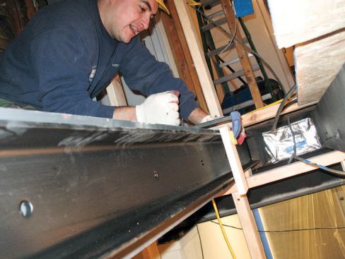 The engineer's plan called for steel reinforcement — plate steel and C-channel — to be bolted to the existing floor joists.
