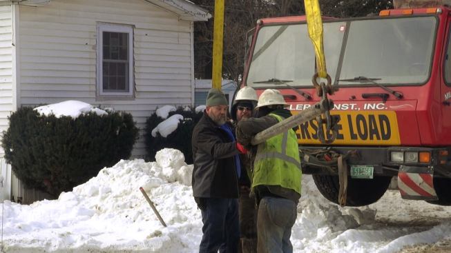 Steve Davis works with the ground crew for the crane company to ready the spreader bar, clevices, and cable for lifting the modular unit and placing the home onto its foundation.