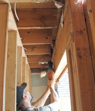 Because the fully assembled beam would measure 4 1/8 inches thick (1 3/4-inch microlam + 5/8-inch steel plate + 1 3/4- inch microlam), we had to cut back the ends of the floor joists 2 5/8 inches to accommodate the additional thickness.