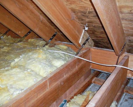 Hurricane clips tie the rafters to the floor joists at the front of the house; shown here is a section of the attic behind a knee wall.