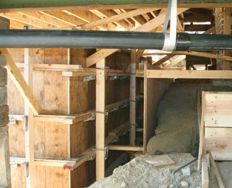 This created a safe though narrow work space for forming and pouring a new retaining wall.