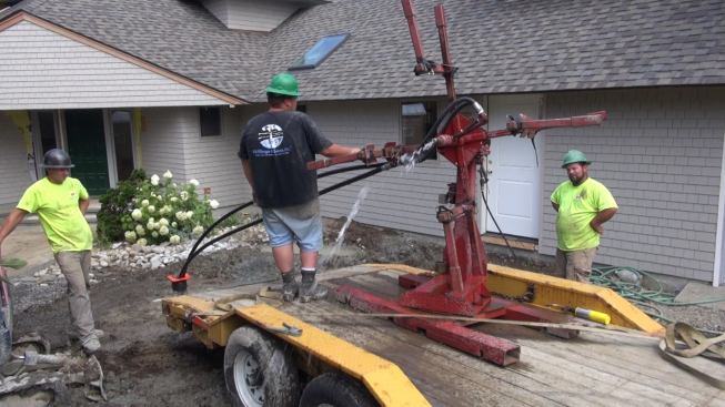 Once the full length of tubing has been inserted into the well shaft, the crew continues to run water into the loop in order to flush out any remaining pockets of air. When the spurts of mixed water and air change over to a continuous flow of water, the crew will disconnect the tube from the water supply and clip the ends.