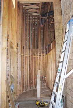 The builder, Alex Abassinnia, made a duplicate of the outside plate and, using a laser for layout, attached it to the ceiling joists 20 feet overhead to facilitate the framing of the tall outer wall.