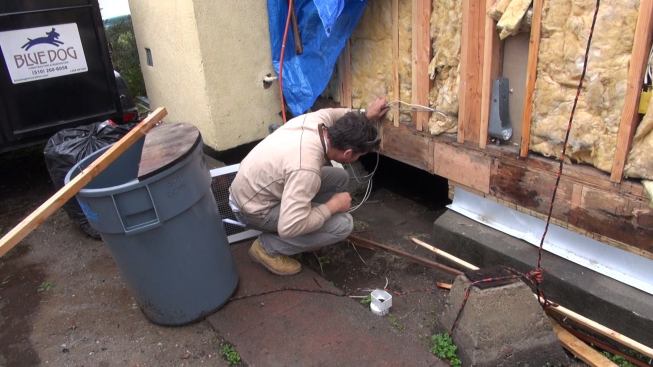 Gregor looks at a space he and his crew used to gain access to the home’s existing foundation and first floor frame, which required extensive reinforcing to get into compliance with California’s stringent seismic requirements. Fortunately, the existing framing had not suffered much deterioration, says Gregor — unlike many other similar structures in the area.