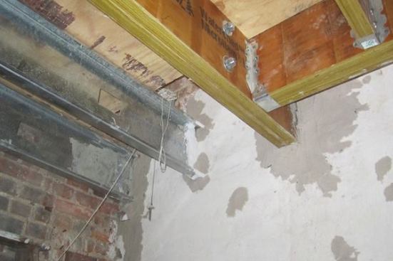 This section of the second-floor frame was in bad condition and had to be completely replaced with steel. To the right of the picture, the LVL beam terminates in the brick wall where the crew had to work around the existing chimney belonging to the neighboring unit.
