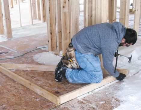 Studs: I laid out the wall studs working backward from the roof layout so the rafters would stack on top of the studs. The 24-inch on-center rafter layout was determined by the depth of the rake overhang — 6 inches, in this case. It pays to take time to get the stud layout right, because that generally eliminates extra cuts in the sheathing. Before nailing the studs in place, we tacked each wall triangle to the edge of the OSB "square" to ensure accuracy.