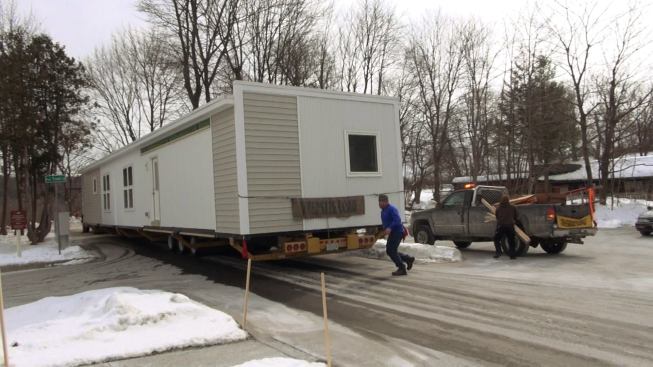 Steve Davis hustles to keep up with his VerMod high-performance modular unit as the tractor-trailer rig carrying the home pulls into the driveway of the mobile home park.