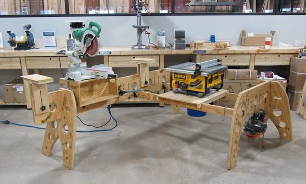 This is one way to set up a mobile shop. Note the various home-made attachments for supporting saws and stock. There’s no reason the saws couldn’t be turned to face the opposite direction or that longer or shorter horses could be used for either leg.