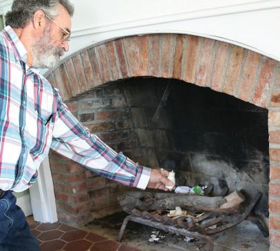 In a depressurized house, air will rush in through any available opening, so combustion appliances need to be shut down during a blower-door test to prevent backdrafting. Here, a smoke puffer indicates that the chimney flue is leaky even with its damper fully closed.