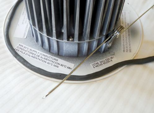 On a can with an integral trim ring that prevents the use of tape, a rolled "shoelace" of duct putty forms a seal.