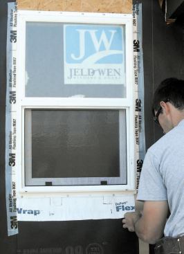 Once the window is nailed off, I use a 3-inch flashing tape, 3M 8067, to seal the flange to the paper along the jambs.