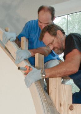 A bar clamp helps the author twist the rail to conform to the curb; bar clamps on the bottom and top forms prevent the rail from jumping over the forms as it is pulled into shape.