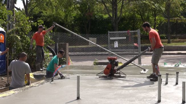 The holdup in the arrival of the last concrete truck meant that finishing of the early deliveries and placement of the final delivery had to happen simultaneously. Here, Evan Smith is almost done power-troweling the second segment of the slab while Steve Daly is still bull-floating the third segment.