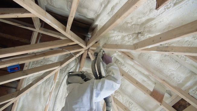 A technician with Portland, Maine-based I&S Insulation, “aka Itchy and Scratchy” (
www.iandsinsulation.com) applies high-density polyiso spray foam insulation to the underside of the home’s existing roof sheathing.