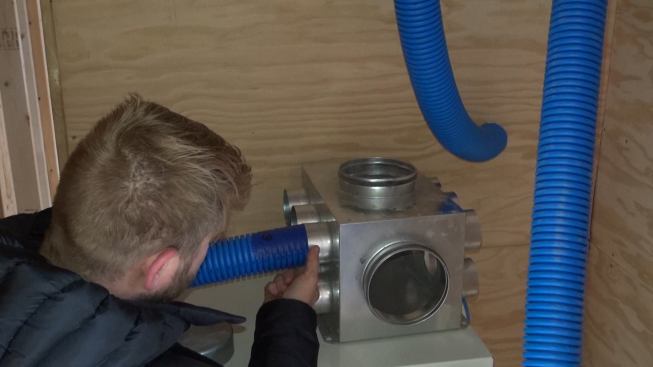 Inside the Blue Hill house, Corson examines the distribution return manifold for the home’s Air Pohoda energy-recovery ventilator, which his crew is still installing. This type of joint will be sealed with tape.