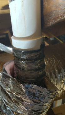After cutting the duct to length, the author tapes its interior sleeve around the damper assembly.