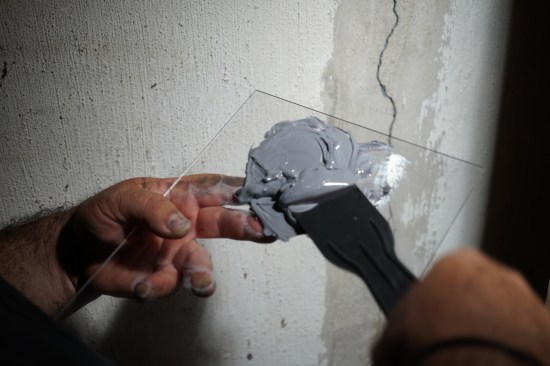 Working in small batches, he mixes a two-part epoxy paste.