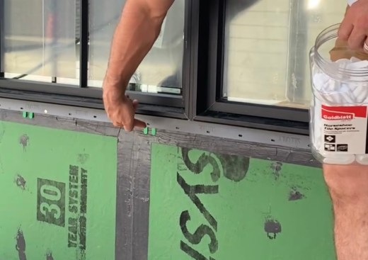  The fluid-applied laps onto the face of the wall to create a “gasket” into which the window flanges are fastened. The author installs horseshoe shims to create a drainage gap along the bottom flange. 
