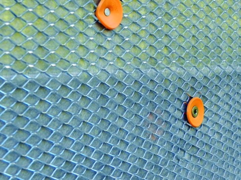 It has a continuous backer, is easy to bend, and is lightweight enough to be tacked up with a hand stapler. The mason then followed, installing an expanded diamond mesh lath, first with 8d nails into the sheathing to hold it in place, then with screws to help flatten out the lath laying over the rainscreen material.