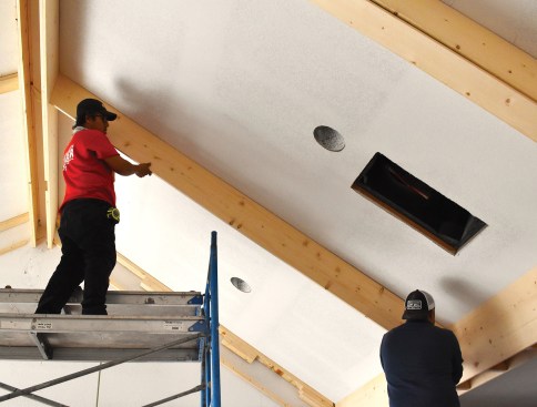 Ensuring the cut beam panels remain straight during install is a two-person job. Shims are used as needed while panels are being nailed to the blocking.