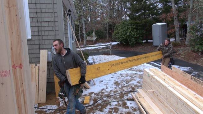 Mike Hill and Russ Laffin carry the main girder for the loft floor frame into the addition.