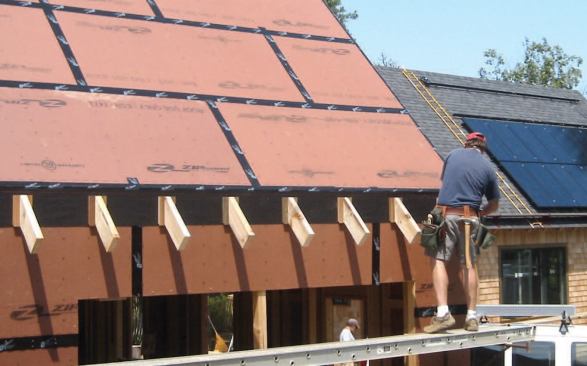 To avoid the gaps in the air barrier that typically occur where the rafters cross the top plates, the author decided to apply false rafter tails to the outside of the airtight shell, first installing a course of a self-adhering flashing membrane to seal fastener penetrations.
