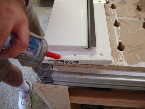 Before the frame is put together, Greg reinserts the weatherstripping and applies a generous bead of caulk to the jamb to seal the joints at all four corners of the frame.