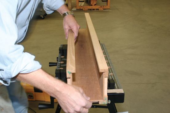 The third panel, with corner frame attached, is slipped over the second plywood panel.
