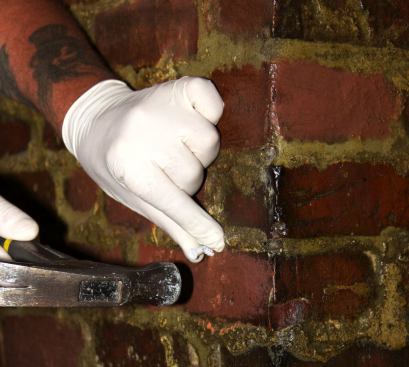Tapping a plastic anchor sleeve into the hole drilled in the mortar of the brick wall. The soft hundred-year-old mortar in the restaurant’s brick walls was crumbly and tricky to work with.