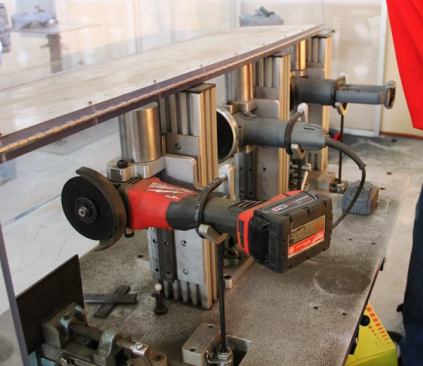This rig was designed to demonstrate cutting speed. The tools are turned on and then allowed to slide down in the fixture while cutting through steel. Cutting pressure is supplied by weights (the silver cylinders) at the top of each fixture. There was a timer but I don’t remember the times. The M18 FUEL grinder beat the “Brand X” tools. The corded grinder in the middle appears to be a Makita and the cordless tool on the right a 20V MAX DeWalt.