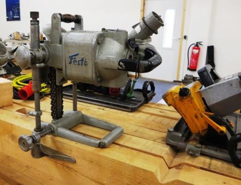 This portable electric chainsaw mortiser would have likely been used for timber framing. Note the positioning stop on the left side of the base and the depth stop on the plunge rod. To the right of the mortise is the type of dadoing circular saw used to cut birds mouths in rafters.