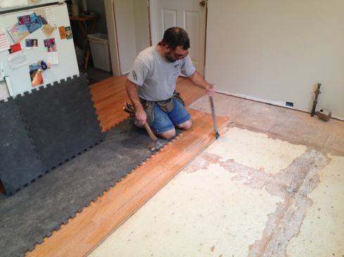 After ripping the adjacent board, Manny pries up the boards saving the complete board to be reused. Now he an run all the flooring in the same direction starting at the wall. All used pieces that are in good shape are cleaned up set aside to be reused later.