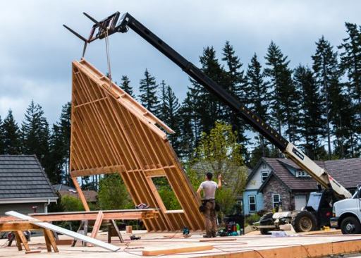 Forklift. In 2005 we bought a used Ingersoll Rand VR 1056 all-terrain forklift for $85,000—and it drastically changed how we frame. We use it to move material and stand walls. With its 56’ reach and 10,000 pound lift capacity we’re able to install soffits and siding with the wall flat on the deck and build larger walls than can safely be lifted by hand or with wall jacks. The forklift also allows us to frame walls where there is space on the deck and then move them to where they need to go. It lives on the jobsite; our excavator charges $230 to transport it.