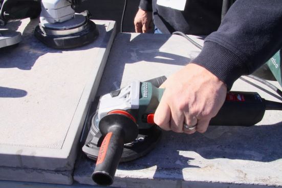 Here Metabo illustrates the adjustable dust shroud on their new 5-in. concrete grinder allowing you to get tight to a wall. This was a feature found on several new grinders at the show among several other tool brands.