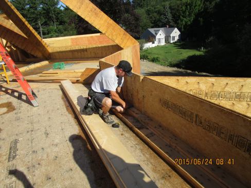 In order to achieve the desired headspace beneath the vaulted ceiling under the roof assembly, carpenters built a double two-by raised plate assembly to catch the feet of the wood I-joist rafters.