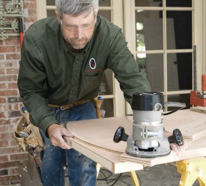 The author cuts segmented arch tops in solid-core door slabs with a router mounted on a trammel arm.
