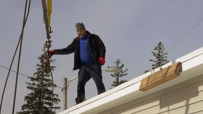 Steve Davis guides lift cables for the modular unit into place.