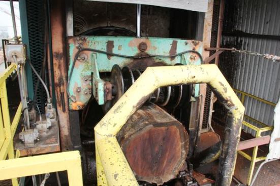 Here a log enters the debarker. It has been through once and is being run through a second time. The debarking machine is a giant ring with rotating cutter blades inside. The ring adjusts to fit different diameter logs, though some of the logs that come to the mill are too big to fit through the machine.