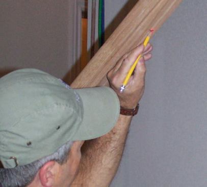 I use a laser to transfer those locations to the underside of the handrail, then drill holes in the rail 3/4 inch deep and about 1/8 inch wider than the diameter of the baluster tops.