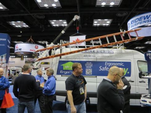 A variety of ErgoRack ladder racks were being shown on vans. This one is on a very tall Sprinter and the fellow in back is in the process of bringing the ladder down. The rear end of the ladder swings farther down and can be brought lower still by pulling on a slide mechanism. The ladder can be lifted off of the rear bracket and then off of the front. 
Click here for video of how the rack works.