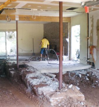 While the perimeter footings were sound, demolition revealed that a slab poured on uncompacted fill was suspended like a trampoline from the footing edges. Note the bow toward the center of the slab remnant.