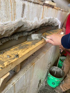 A crew member packs the repair mortar in short lifts. 