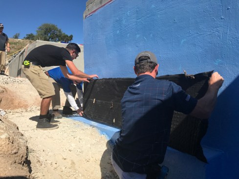 The adhesive is allowed to flash off. Then the drain board is applied to the wall.