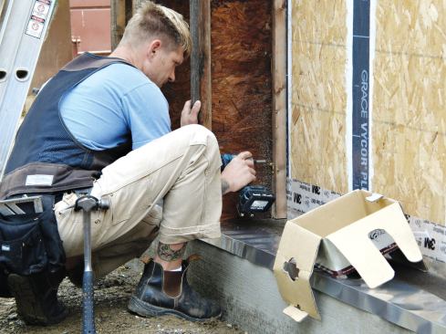 Twelve-inch-deep wood I-joists were fastened to the studs of the inner wall with GRK structural screws to create space for cellulose insulation.